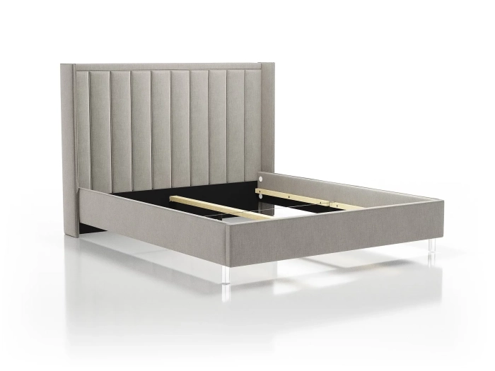 Łóżko 81245 tapicerowane w jasnoszarym kolorze, z wysokim pionowo pikowanym zagłówkiem i przezroczystymi nogami, bez materaca.