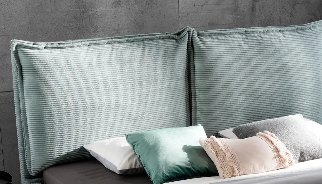 Zbliżenie na wezgłowie z poduszkami łóżka Charlotte